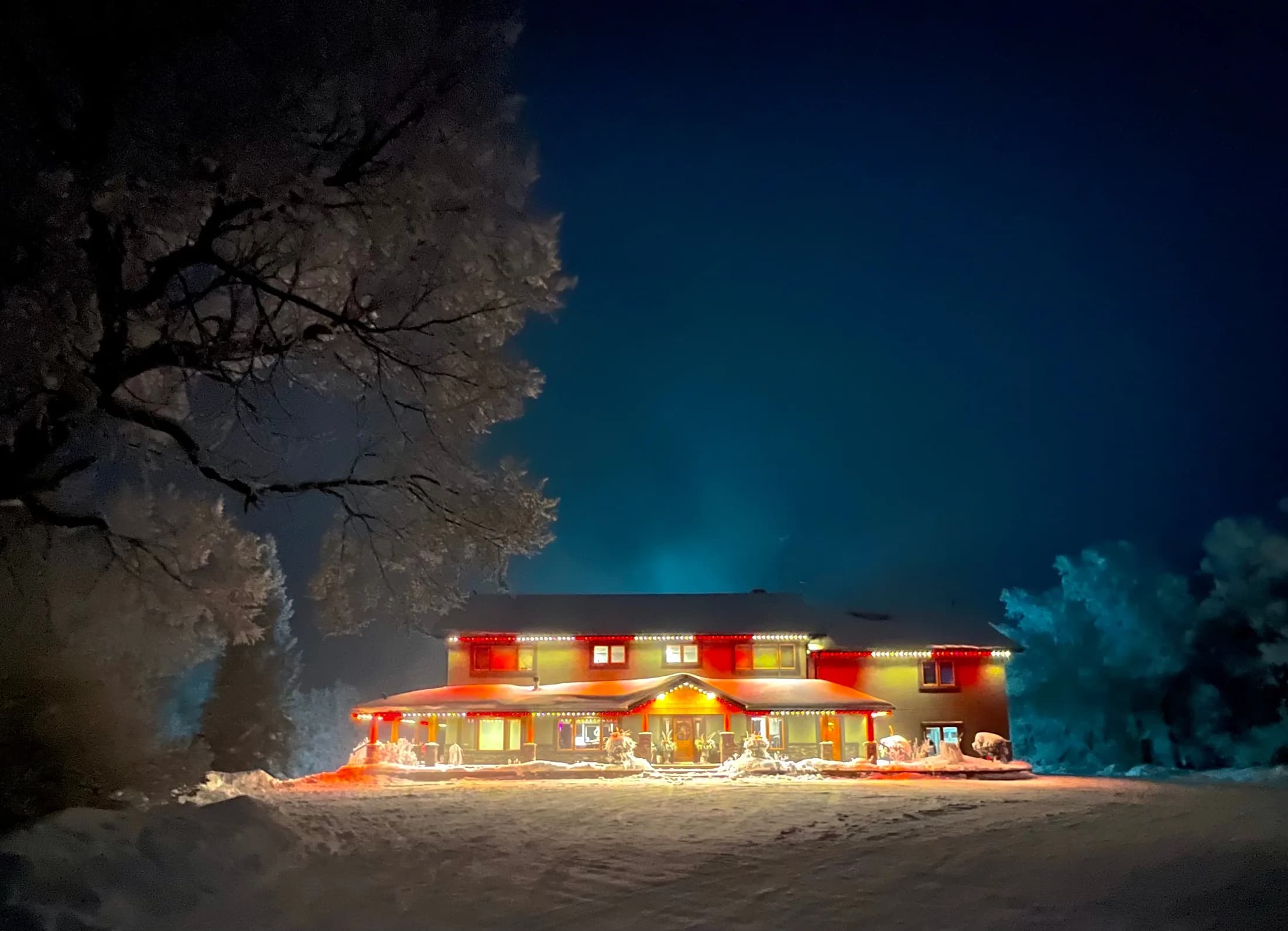 Permanent LED roofline lighting set to warm white for Christmas on a brick home