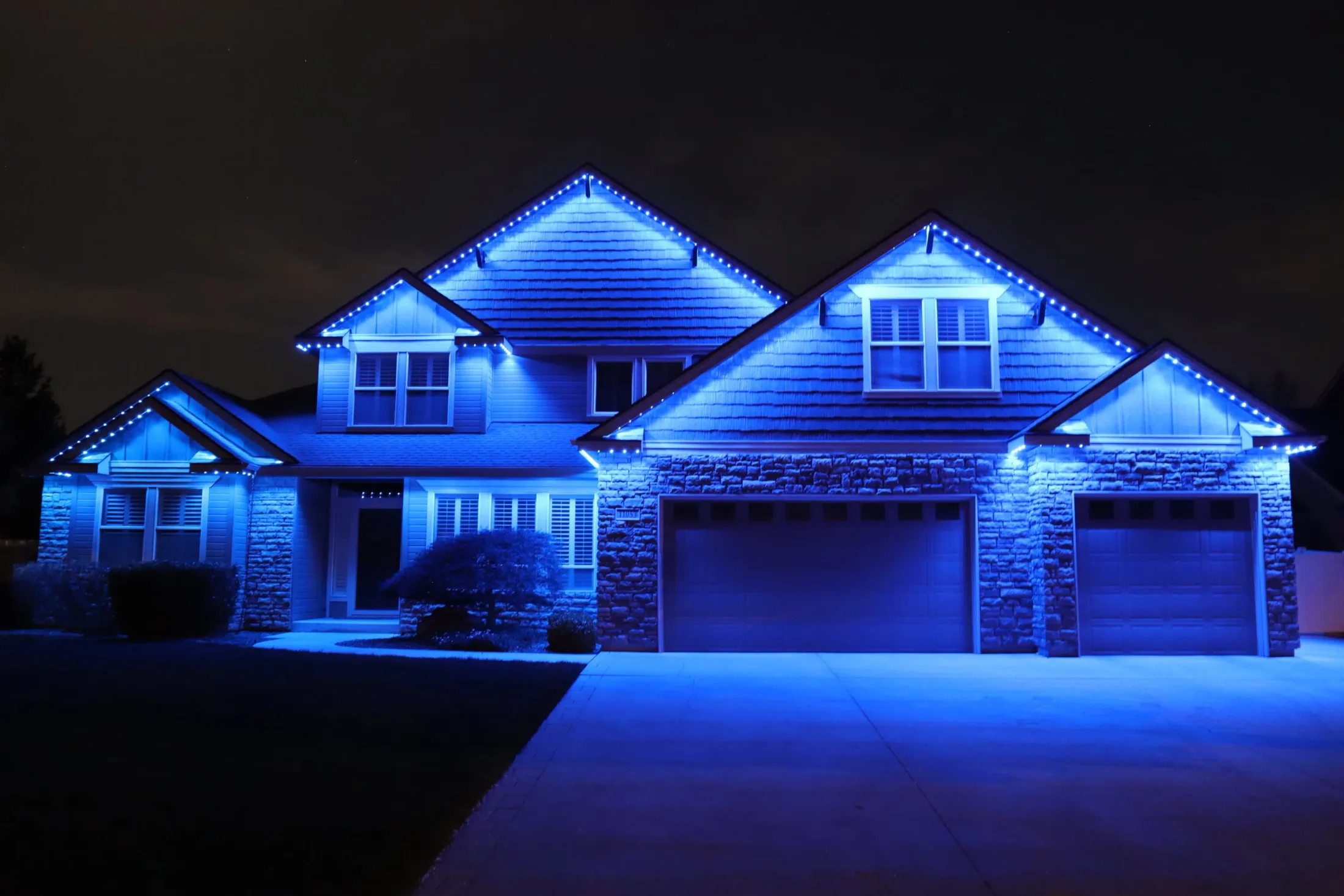Home fully outlined at night by permanent LED roofline lighting