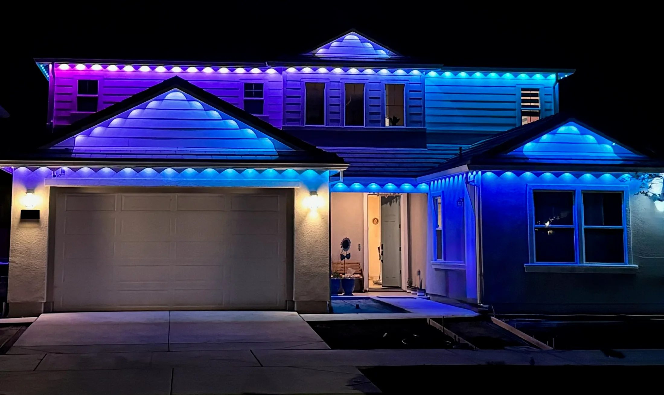Wide building elevation lit end to end with permanent LED track lighting at night
