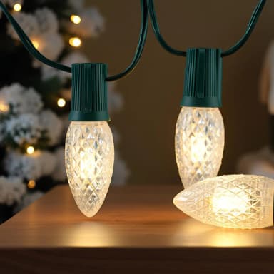 Warm white C9 bulbs glowing on a green socket strand